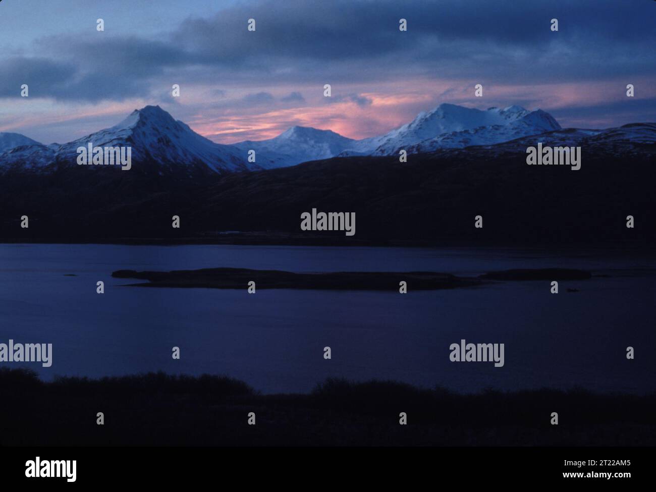 View of snow-covered mountains over Women's Bay at Kodiak Island. Subjects: Mountains; Snow; Scenics. Location: Alaska.  . 1998 - 2011. Stock Photo