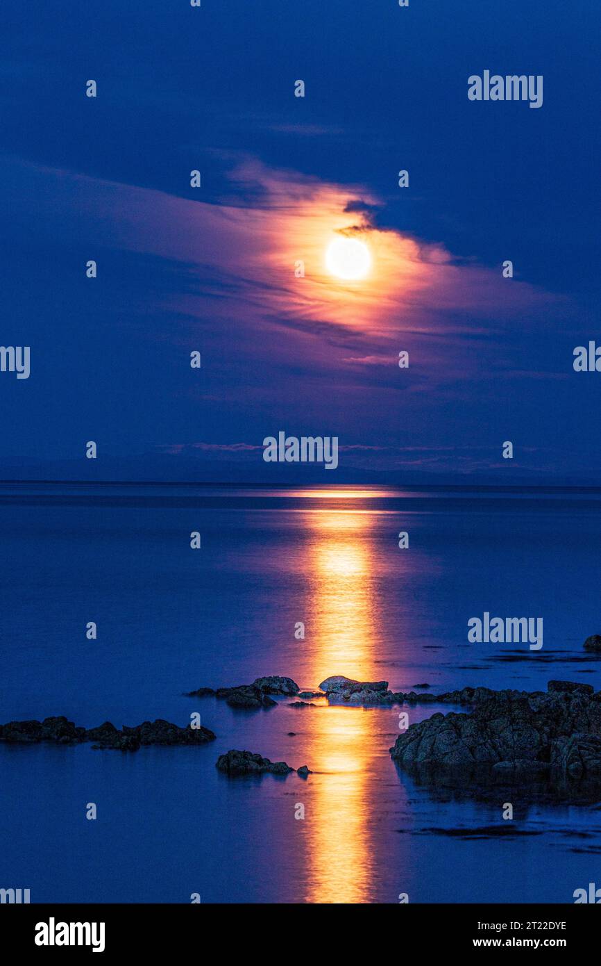 The super moon (a blue moon) on 30/8/2023 rising over the Isle of Arran seen from the Kintyre Peninsula, Scotland UK Stock Photo