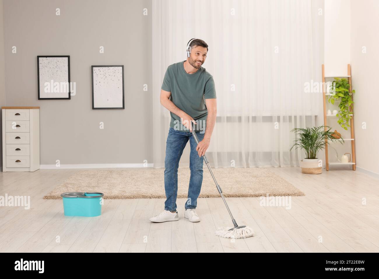 https://c8.alamy.com/comp/2T22EBW/enjoying-cleaning-man-in-headphones-listening-to-music-and-mopping-floor-at-home-2T22EBW.jpg