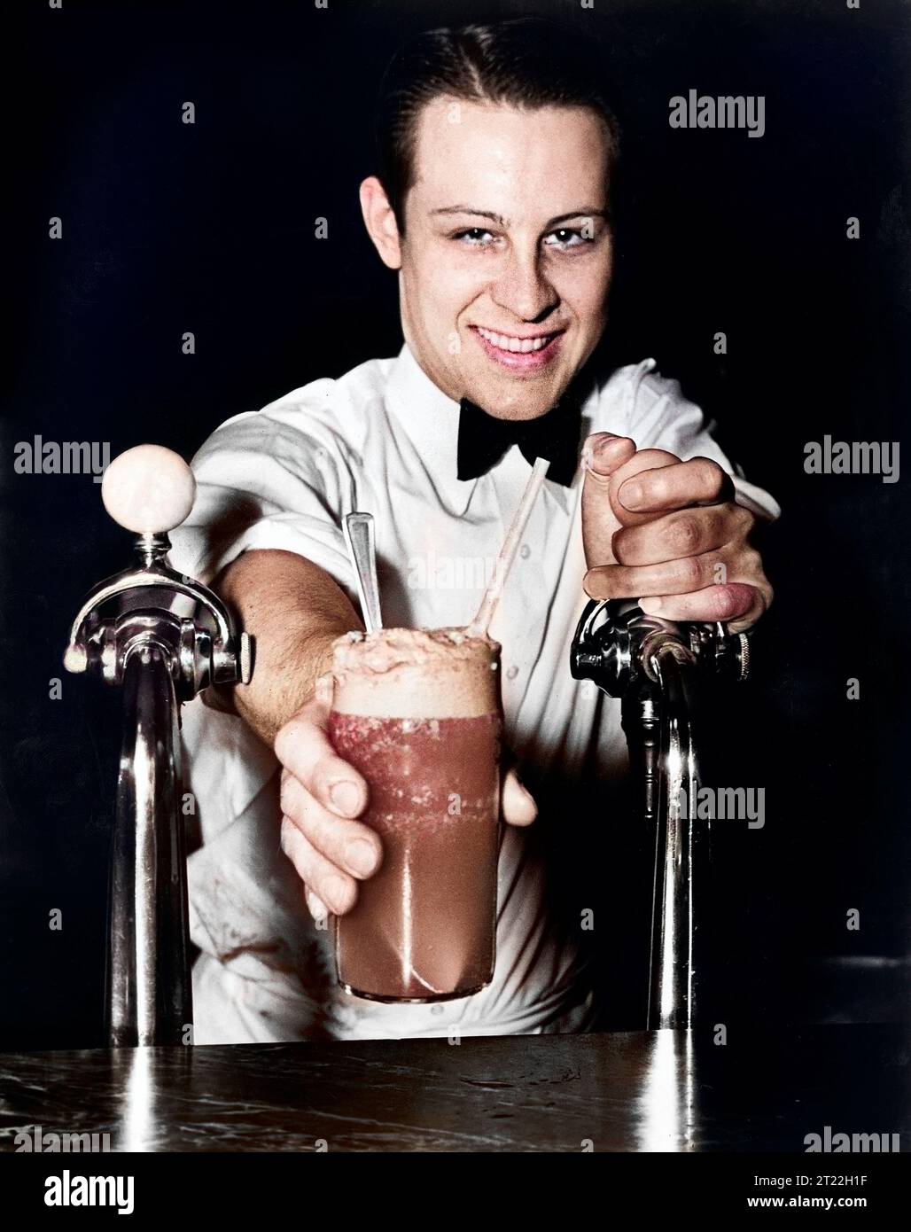 "Soda jerk" passing ice cream soda between two soda fountains, New York