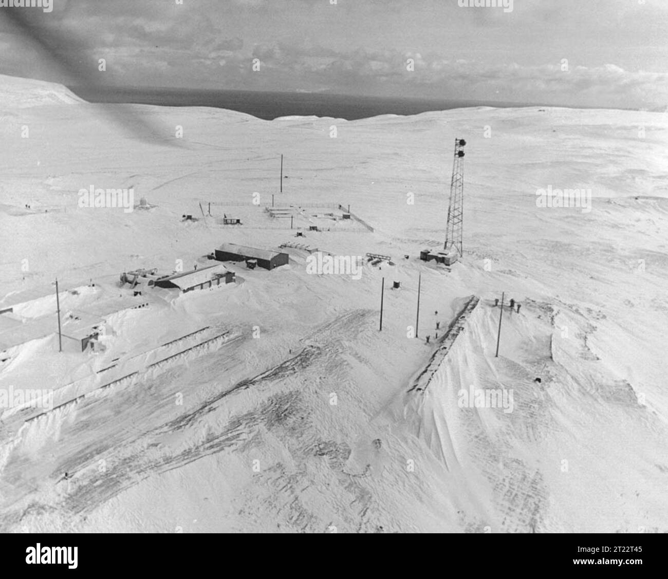 Aerial winter photo Atomic Energy Commission installation at the western end of Amchitka Island. Roads to the east end are cut off during winter snows. Strong winds cause much drifting. Subjects: Wildlife refuges; Alaska Maritime National Wildlife Refuge; Aleutians; ARLIS; Alaska. Stock Photo