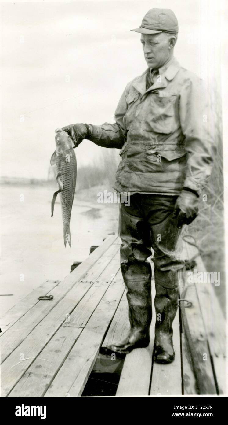 Fishy Reporting A worker displays a fish specimen at a hatchery or field station ...