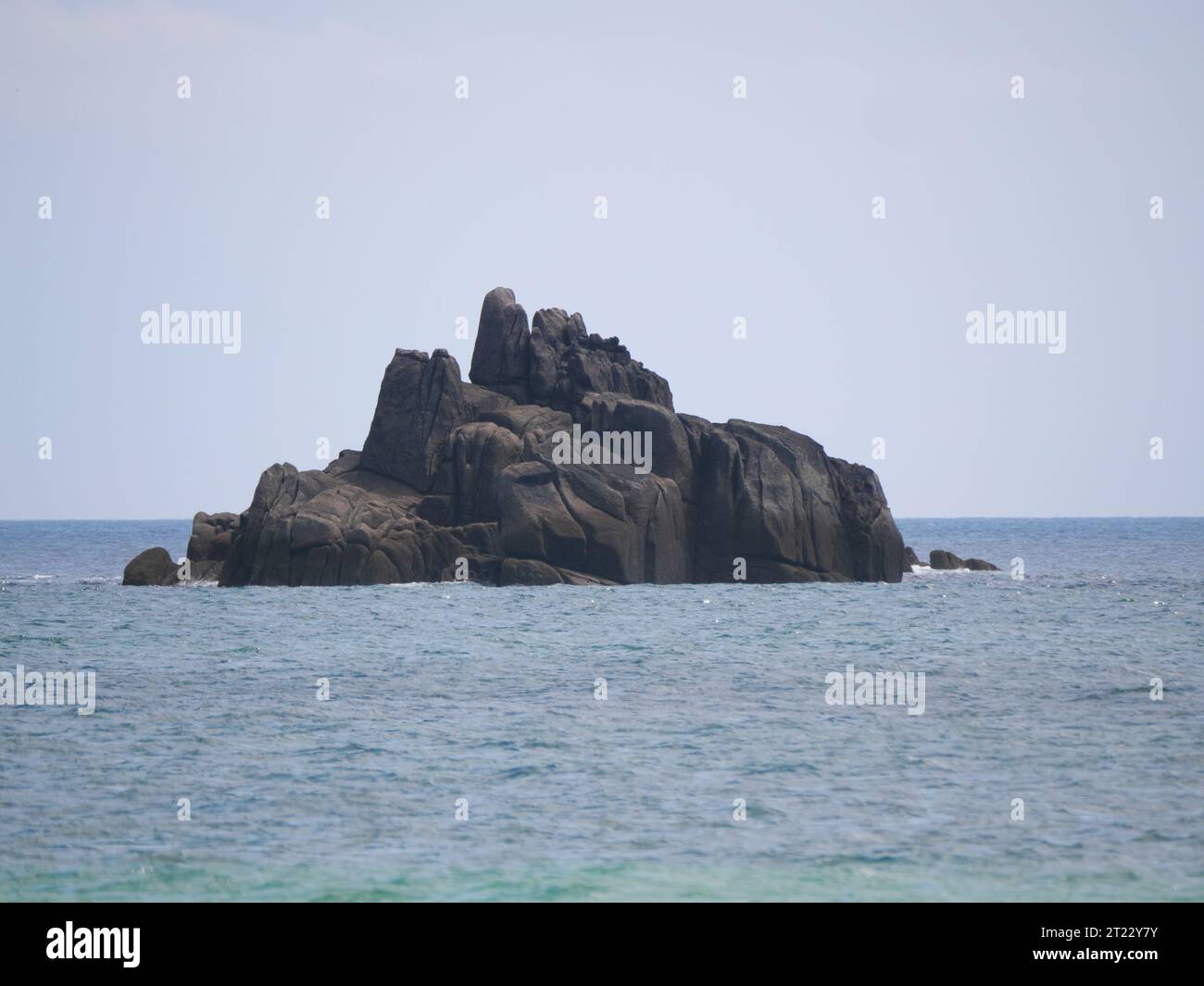 Offshore rock island in front of the beach of Porthcurno in Cornwall ...