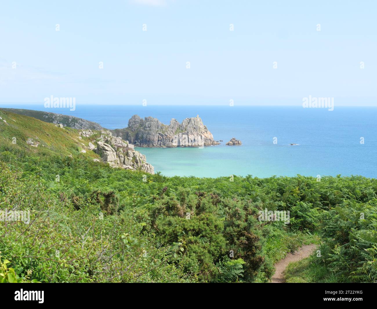 The coastal footpath walking among fern vegetation at Porthcurno in Cornwall England Stock Photo