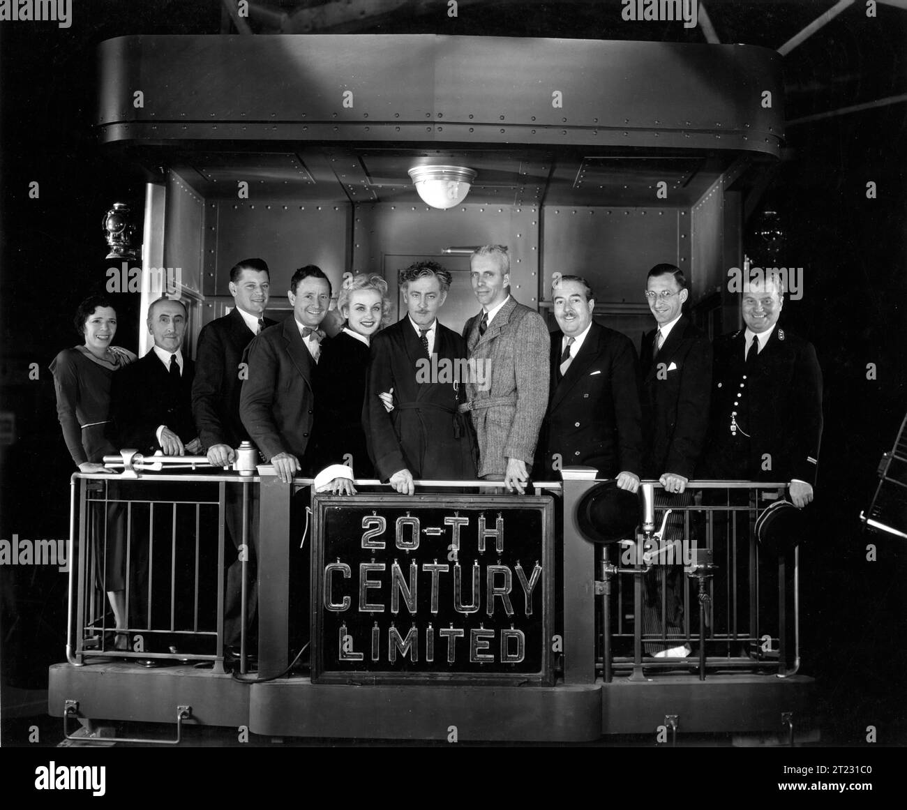 CAROLE LOMBARD, JOHN BARRYMORE and Director HOWARD HAWKS with members of the cast (left to right) Dale Fuller,, Etienne Giradot, Ralph Forbes, Roscoe Karns, Carole Lombard, John Barrymore, Howard Hawks, Walter Connolly,Charles Lane and James B. Burtis on the set of TWENTIETH CENTURY 1934 Screenplay BEN HECHT and CHARLES MacARTHUR Columbia Pictures Stock Photo