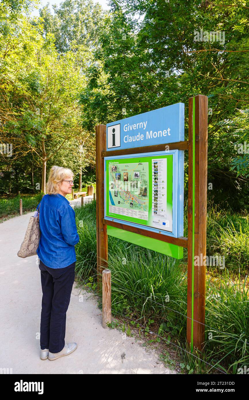 A visitor reads the layout map at the entrance to Giverny, the garden of French impressionist painter Claude Monet, Normandy, northern France Stock Photo