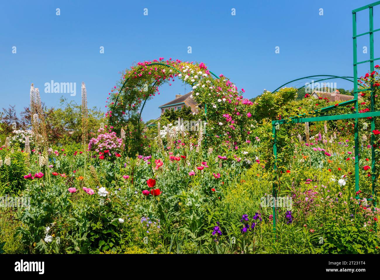 Rose arches and colourful summer flower borders in Giverny, the garden of French impressionist painter Claude Monet, Normandy, northern France Stock Photo
