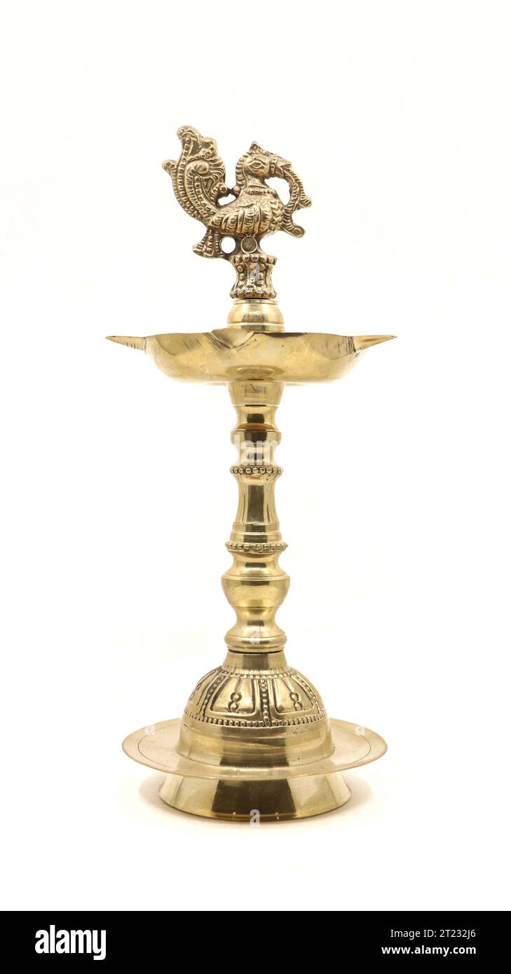 a vintage indian samai or vilakku, an oil lamp with a peacock bird emblem used to light fire and pray to god during religious events and rituals Stock Photo