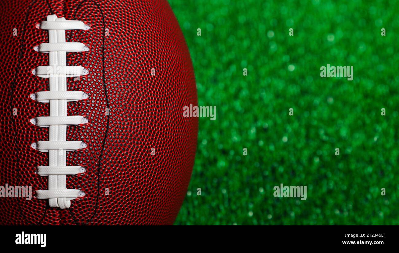 Close-up of the stringing of a brown american football ball over green grass. Stock Photo