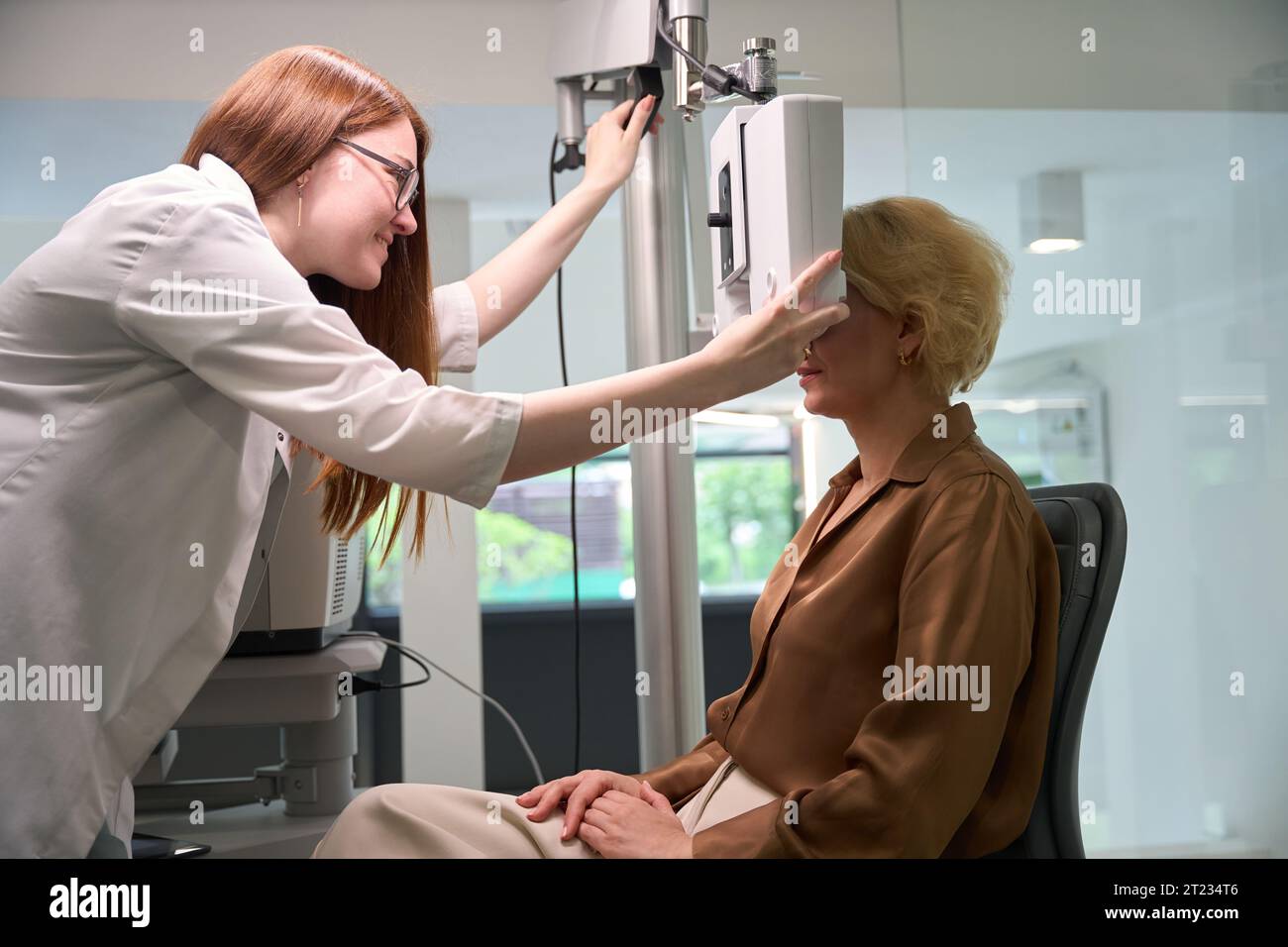 Red-haired doctor uses modern equipment in her work Stock Photo