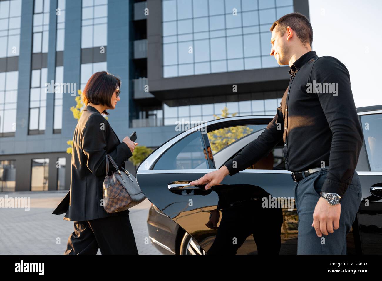 https://c8.alamy.com/comp/2T236B3/chauffeur-helps-an-elegant-business-woman-gets-in-car-2T236B3.jpg