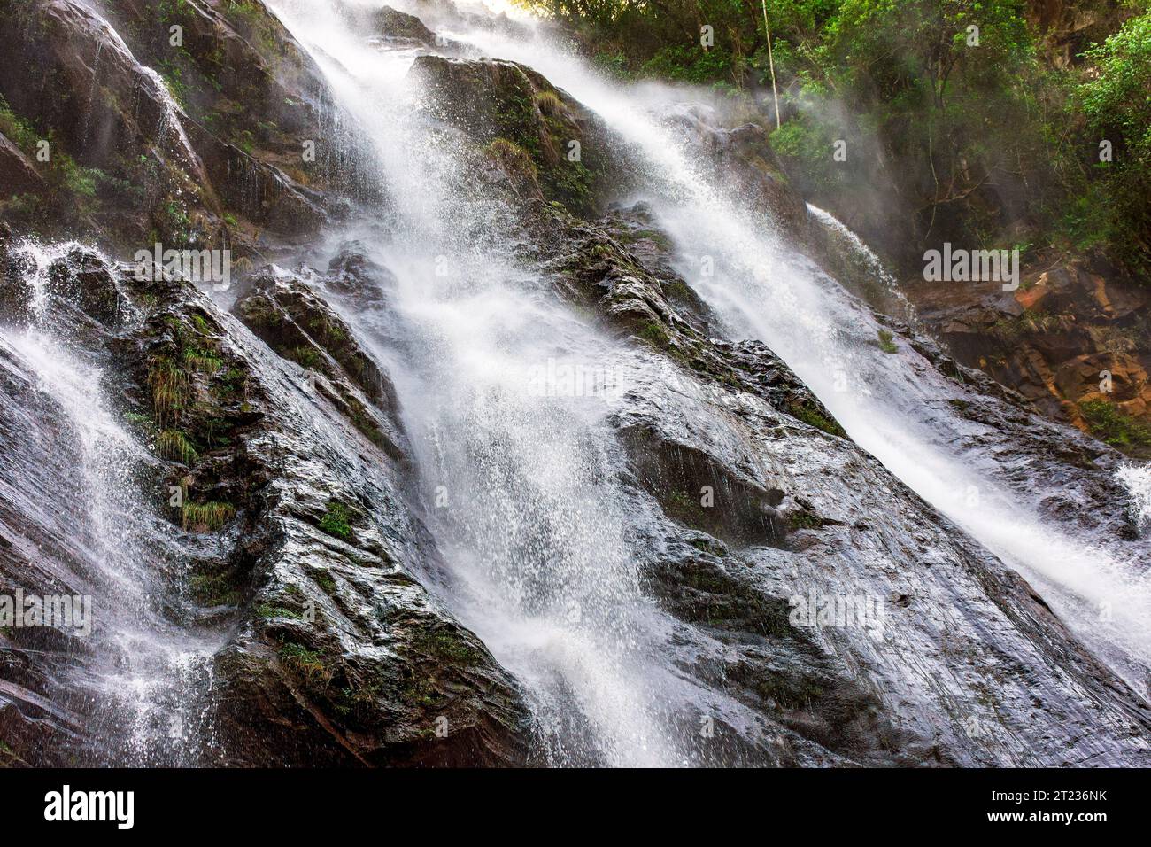 Beautiful waterfall with water flowing between the rocks and the forest in Minas Gerais, Brazil Stock Photo