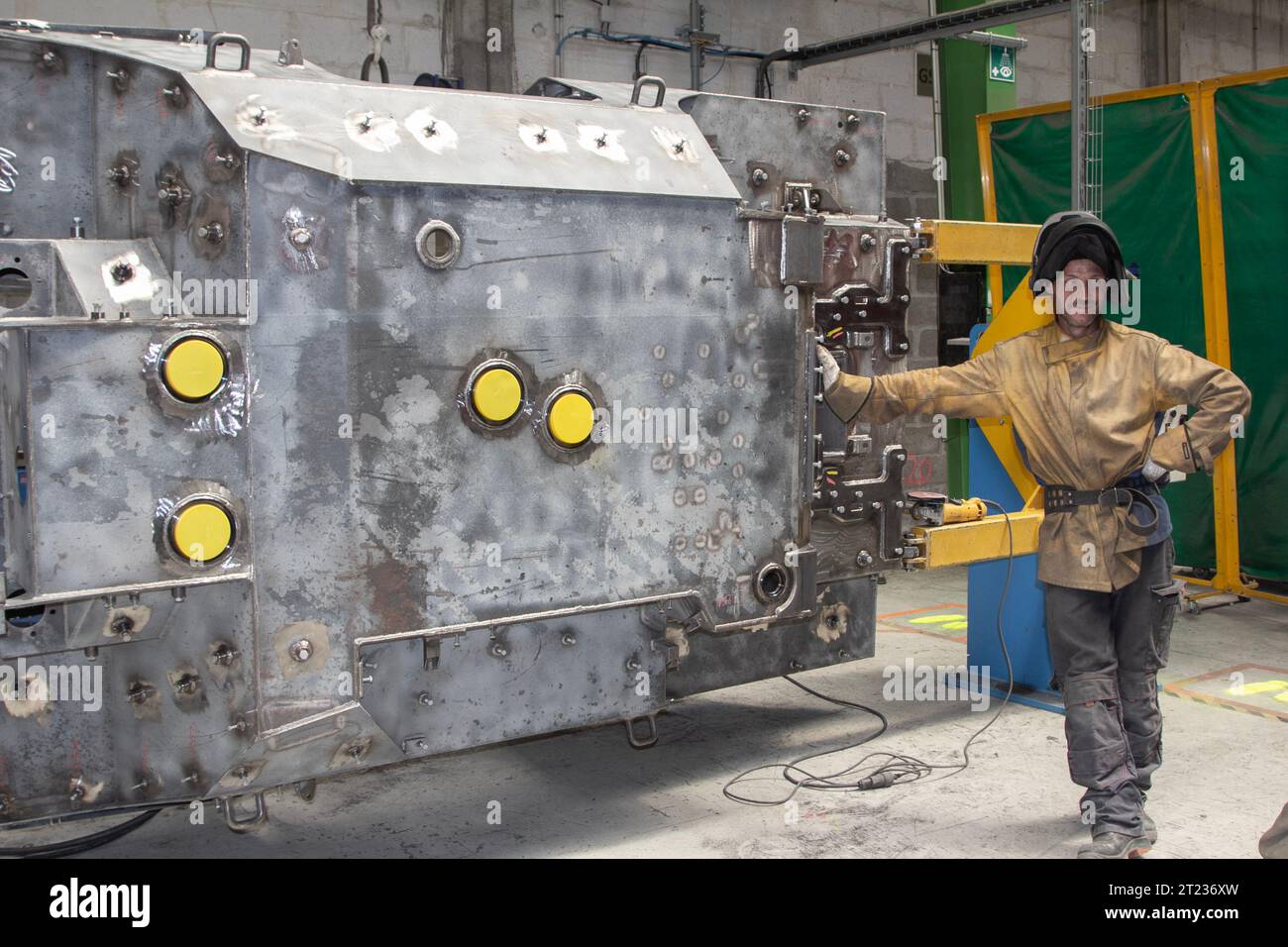 France: a solderer takes a pause near a piece of machinery in a factory. Stock Photo