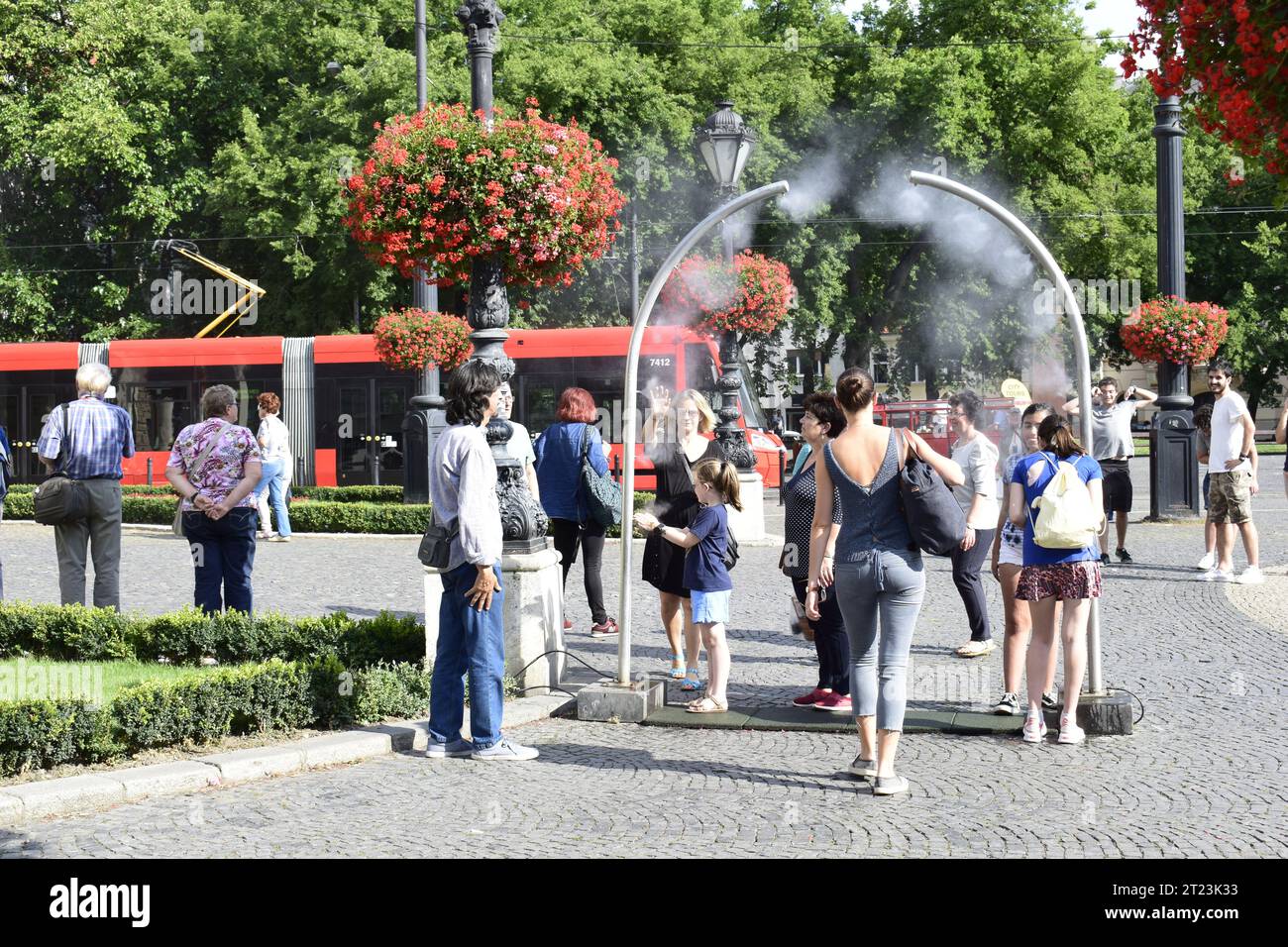 BRATISLAVA, SLOVAKIA - JULY 19, 2018: People enjoy a cooling water spray in Bratislava city center on a hot sunny summer day Stock Photo