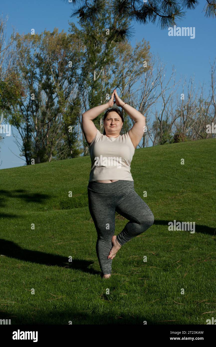 Fitness, outdoor training, weight loss. Fat woman doing exercises in