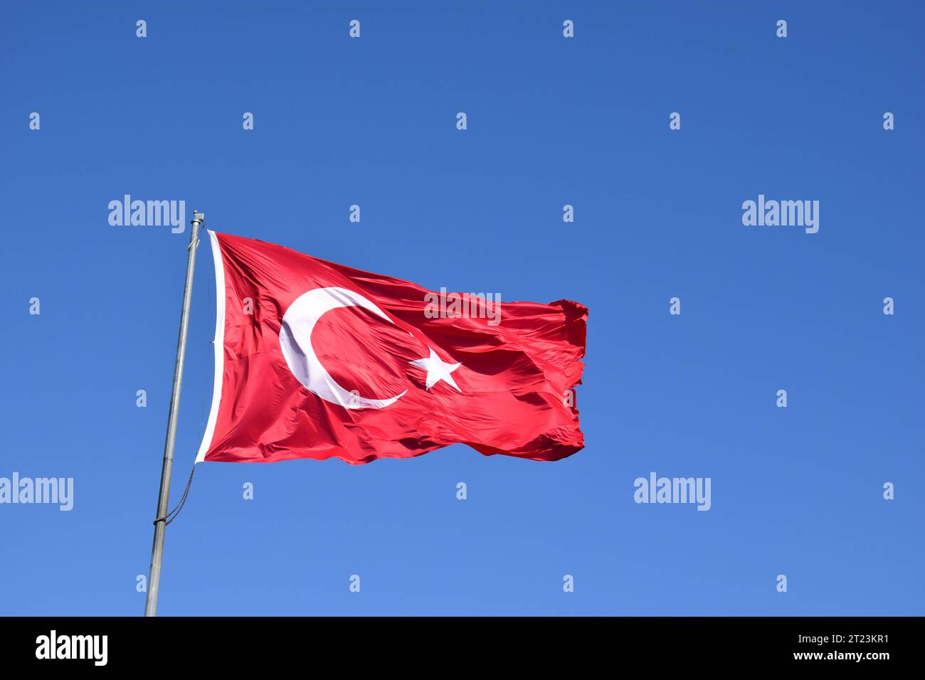 Waving Turkish Flag or Flag of Turkey on Blue Sky. Stock Photo