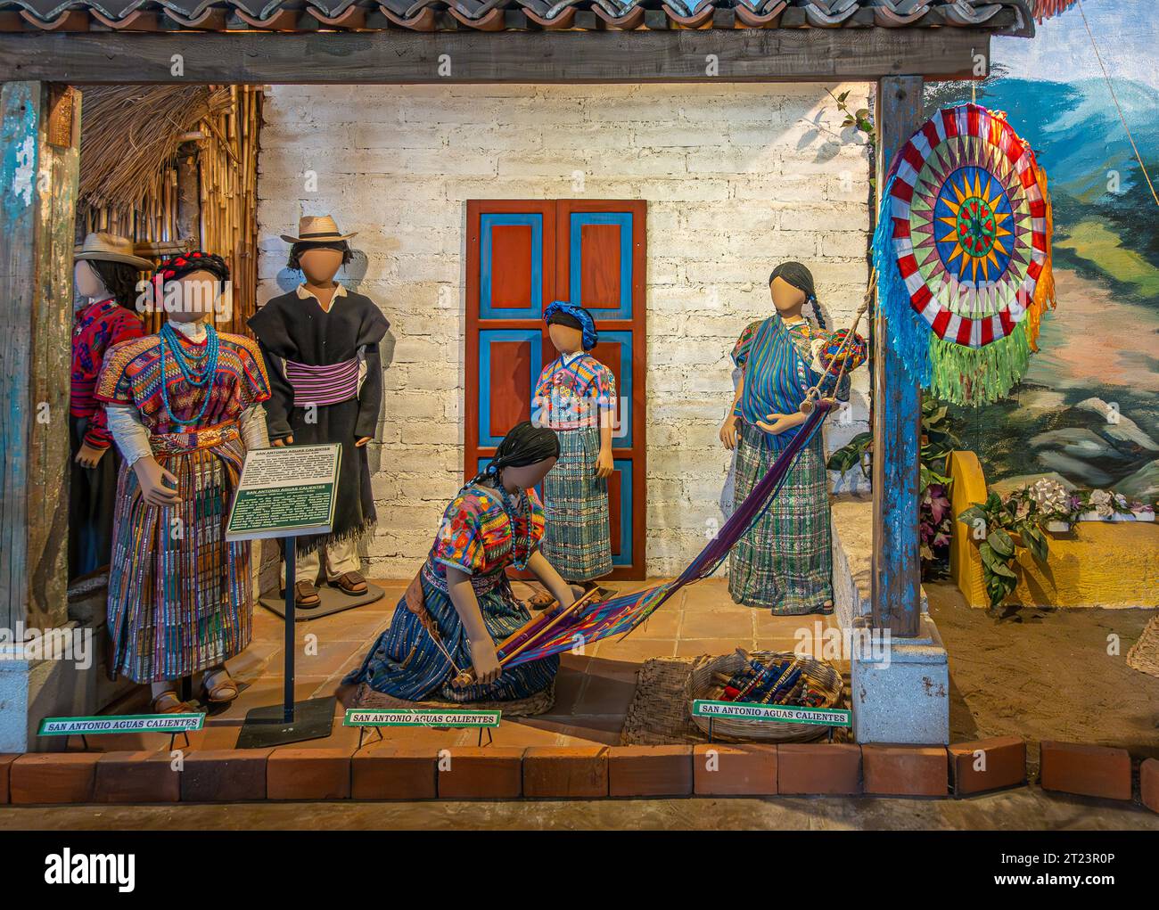 Guatemala, La Antigua - July 20, 2023: Finca La Azotea museums. Colorfully and traditionally dressed dolls set at outdoor manual weaving scenery. Pain Stock Photo