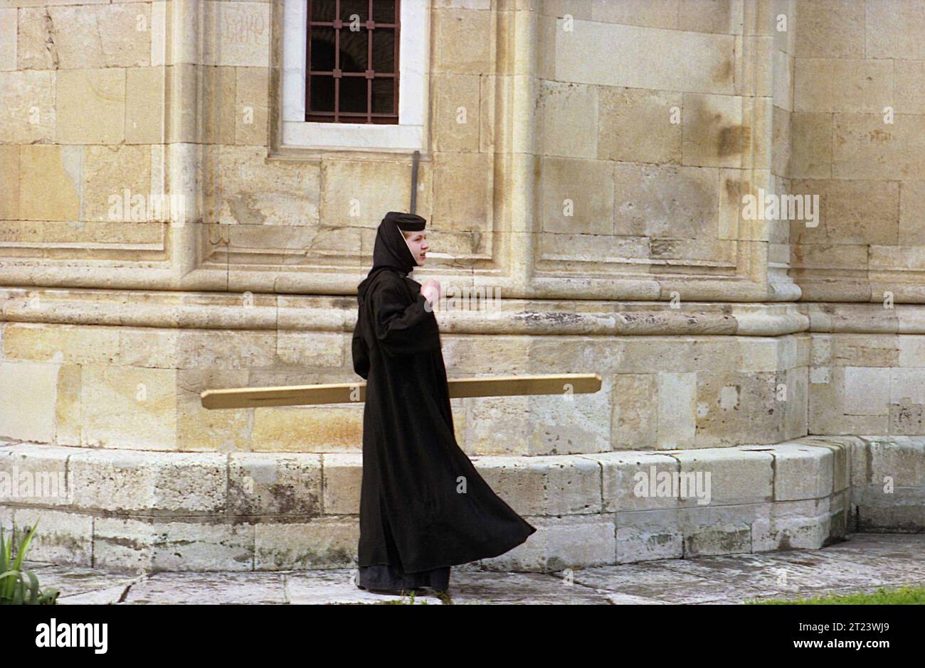 Dambovita County, Romania, 1991. Nun playing the semantron at Dealu Monastery. Stock Photo
