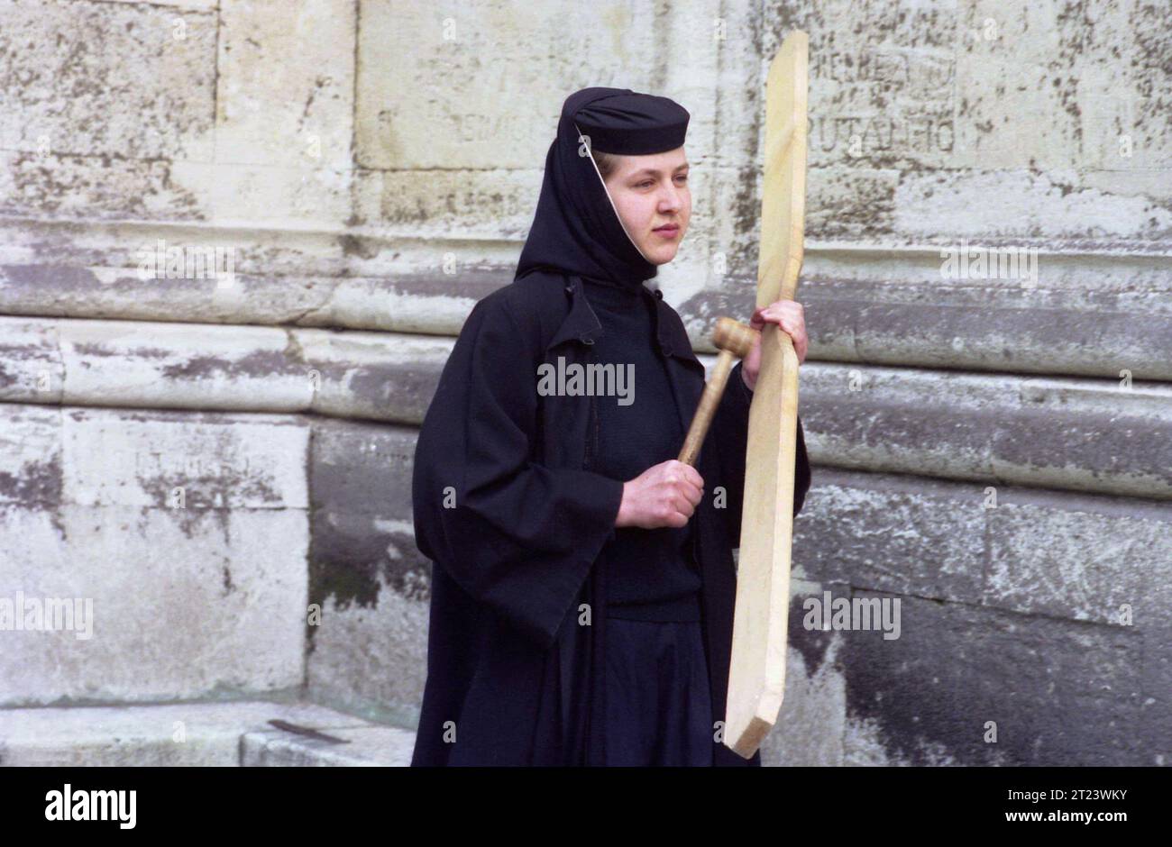 Dambovita County, Romania, 1991. Nun playing the semantron at Dealu Monastery. Stock Photo