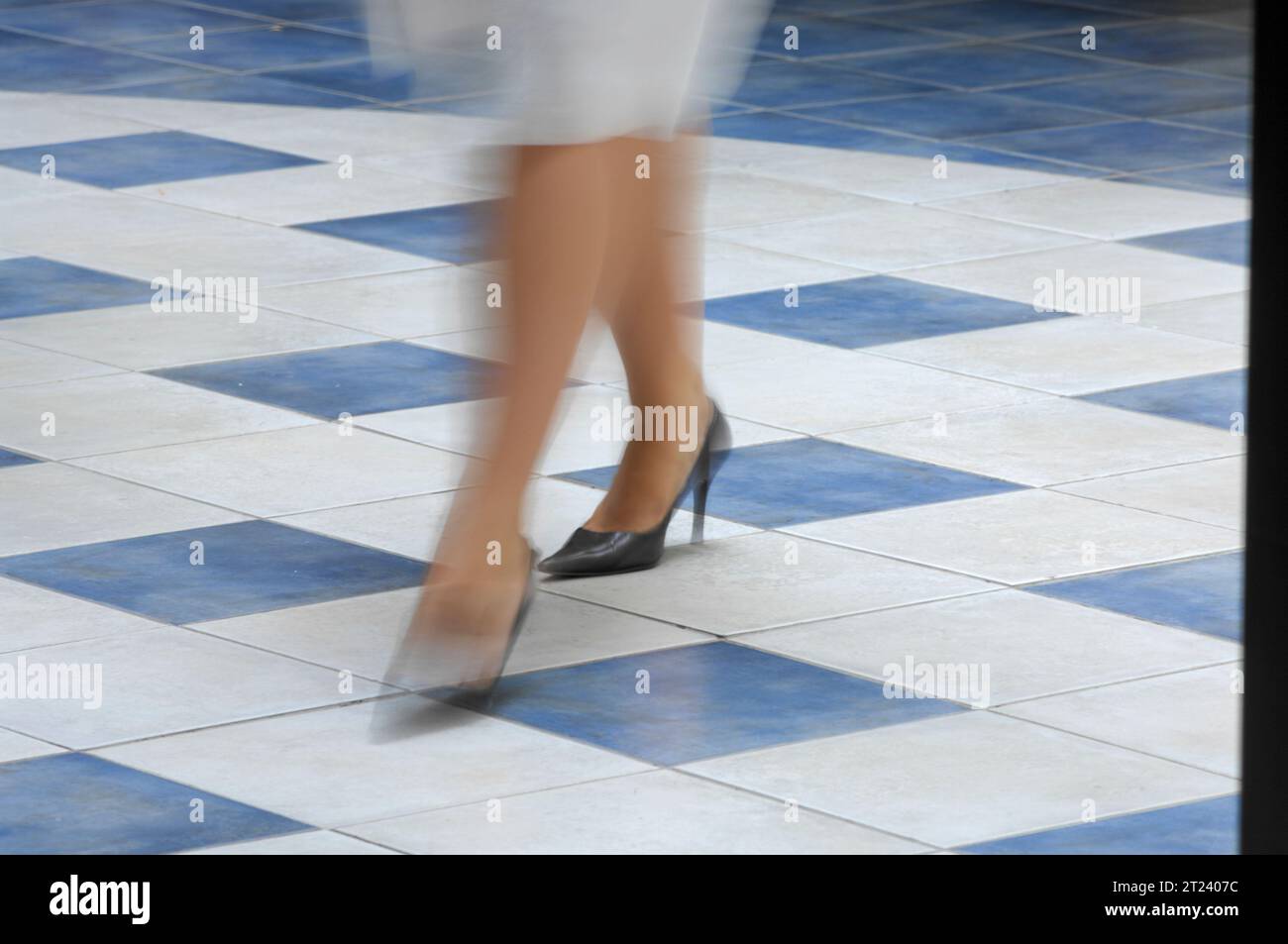 Blurred womens legs, running in skirt and high heels on tiled floor Stock Photo Alamy