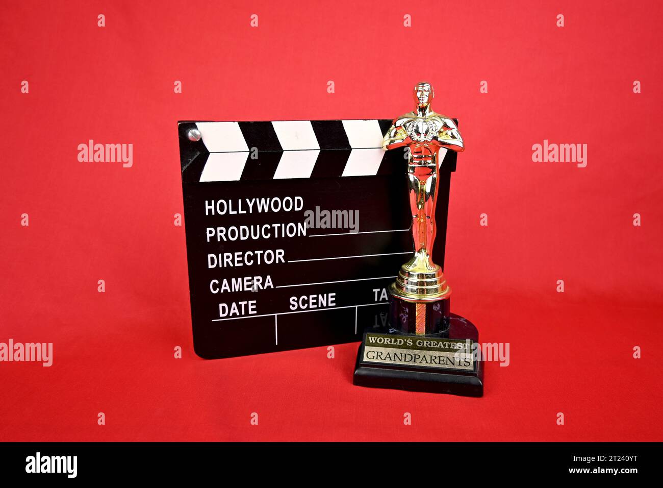 Novelty film oscar award and movie clapperboard on a red background Stock Photo