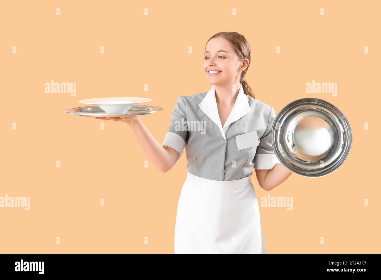 https://c8.alamy.com/comp/2T243K7/young-waitress-with-empty-plate-tray-and-cloche-on-beige-background-2T243K7.jpg