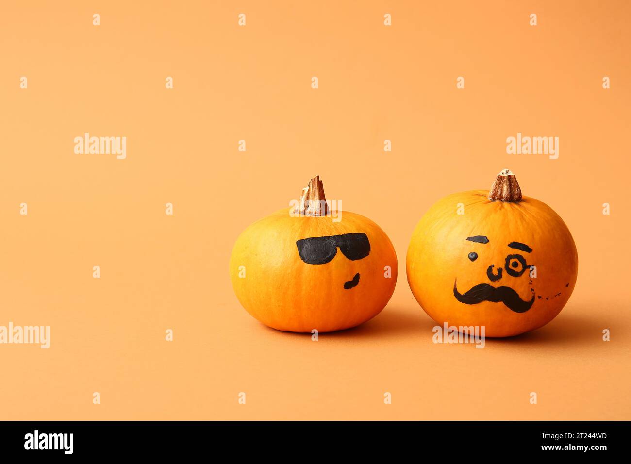 Funny Halloween pumpkins with drawn faces on orange background Stock ...