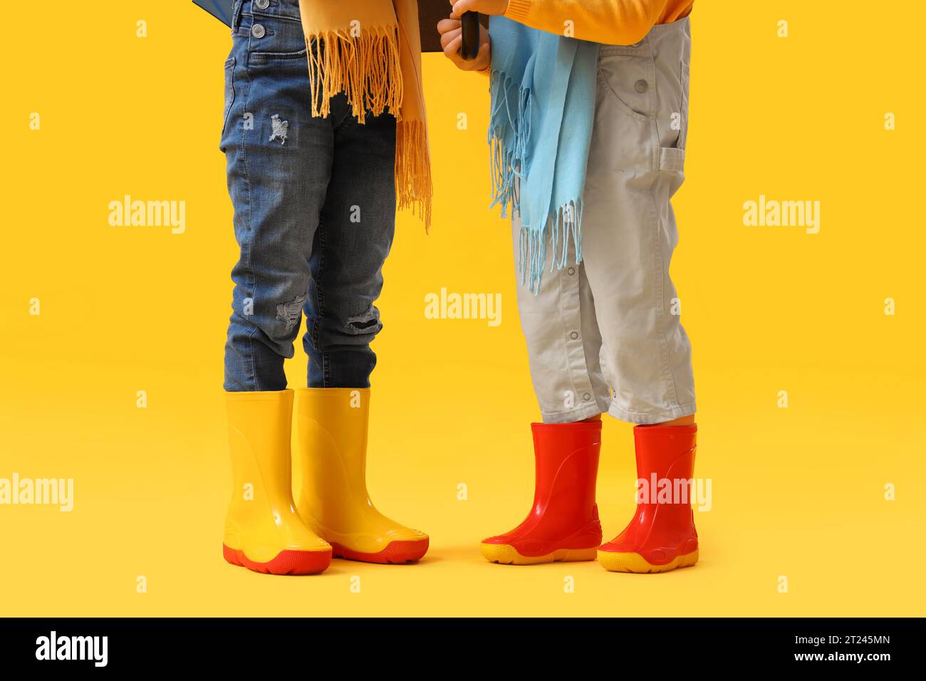 Little children in rubber boots on yellow background Stock Photo Alamy