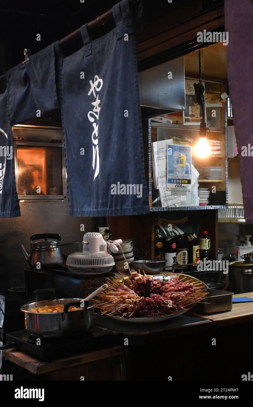 Streetfood stall serving meat on skewers, named Yakitori in Tokyo Japan. Located in Shinjuku, at Yakitori Alley (Omoide Yokocho) or Memory Lane Stock Photo