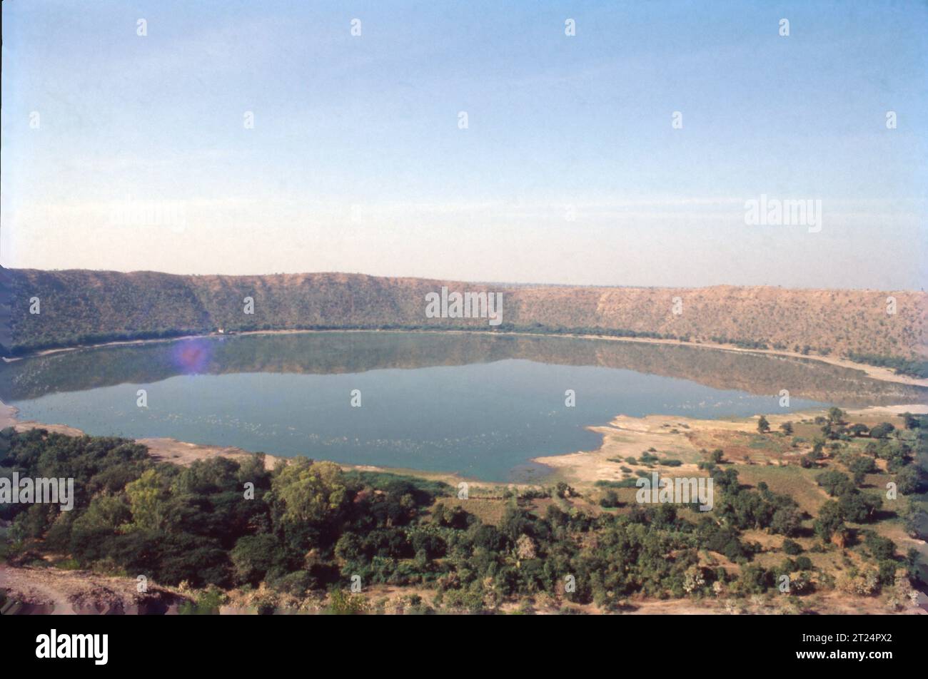 Lonar Lake, also known as Lonar crater, is a notified National Geo-heritage Monument, saline, soda lake, located at Lonar in Buldhana district, Maharashtra, India. Lonar Lake is an astrobleme created by a meteorite impact during the Pleistocene Epoch. Stock Photo