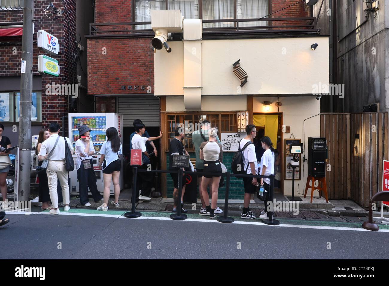 Queueing for a restaurant in Tokyo. People waiting in line outside of Udon Shin Restaurant to eat Udon noodles, famous in the Tokyo culinary scene Stock Photo