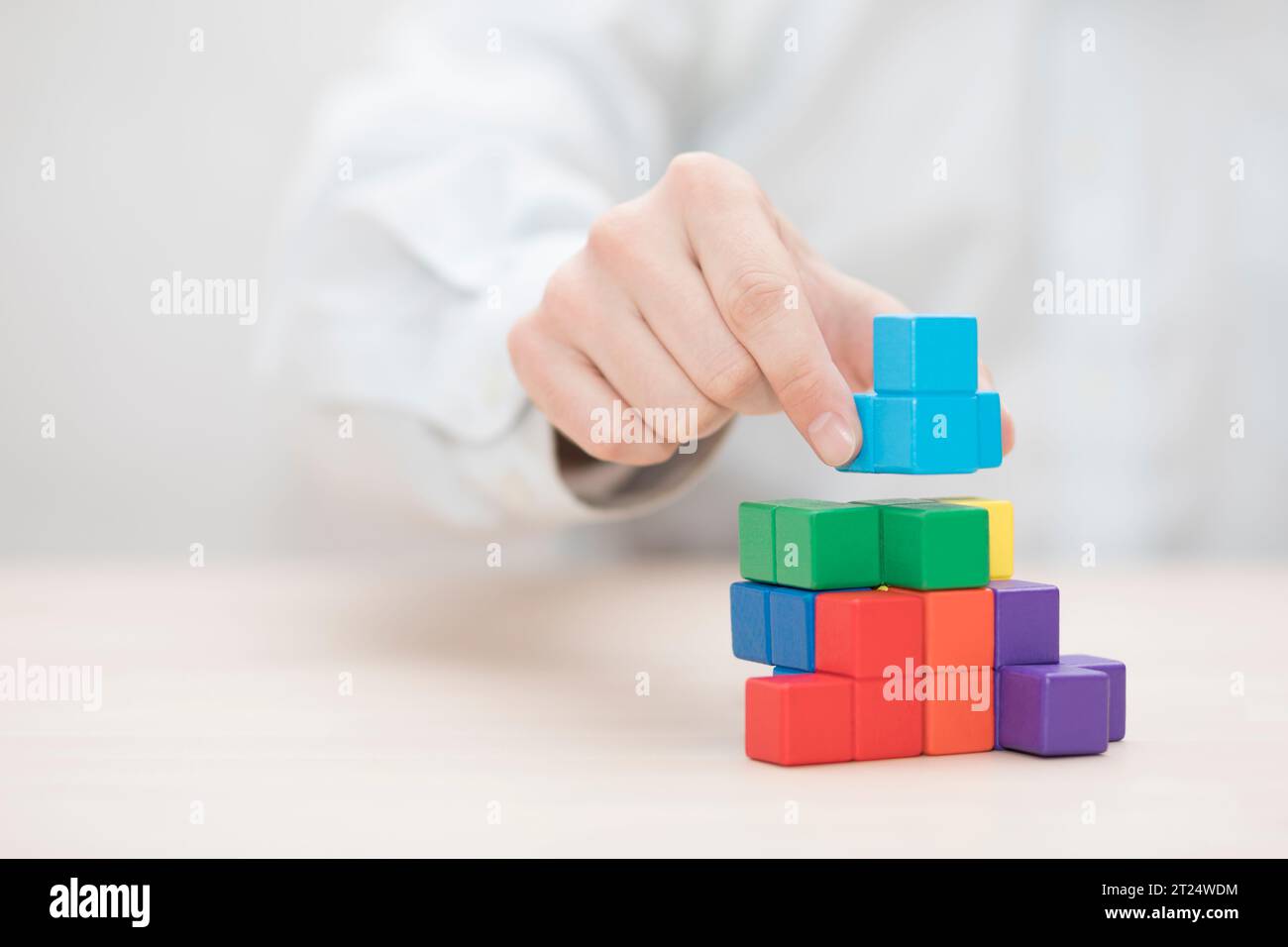 Man's hand stacking colorful wooden blocks. Business development concept Stock Photo