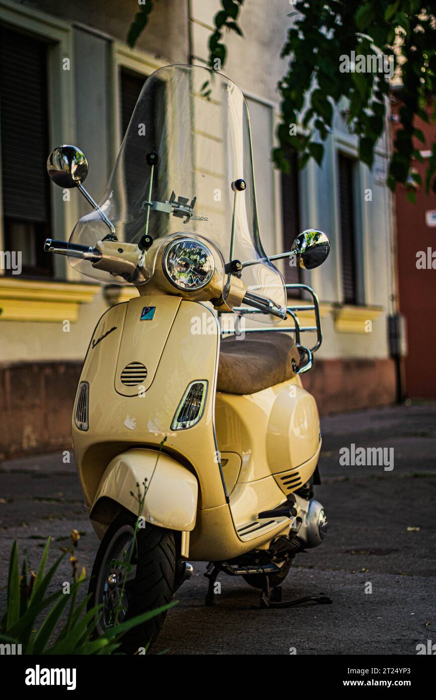 Yellow Vespa Scooter Motorcycle front of the house Stock Photo