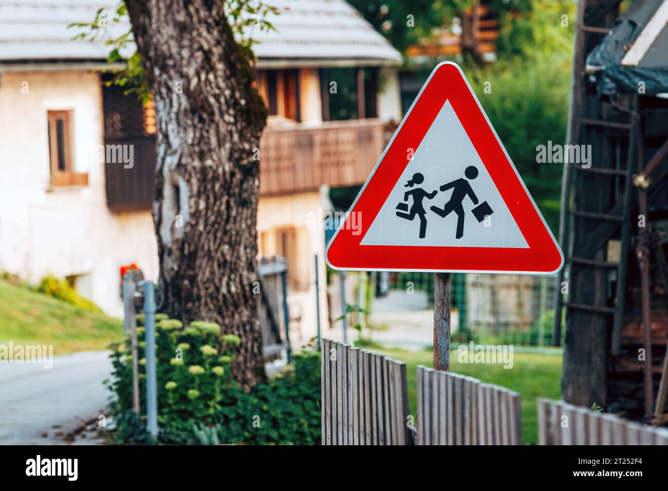 School children crossing road traffic sign in alpine village in Slovenia, selective focus Stock Photo