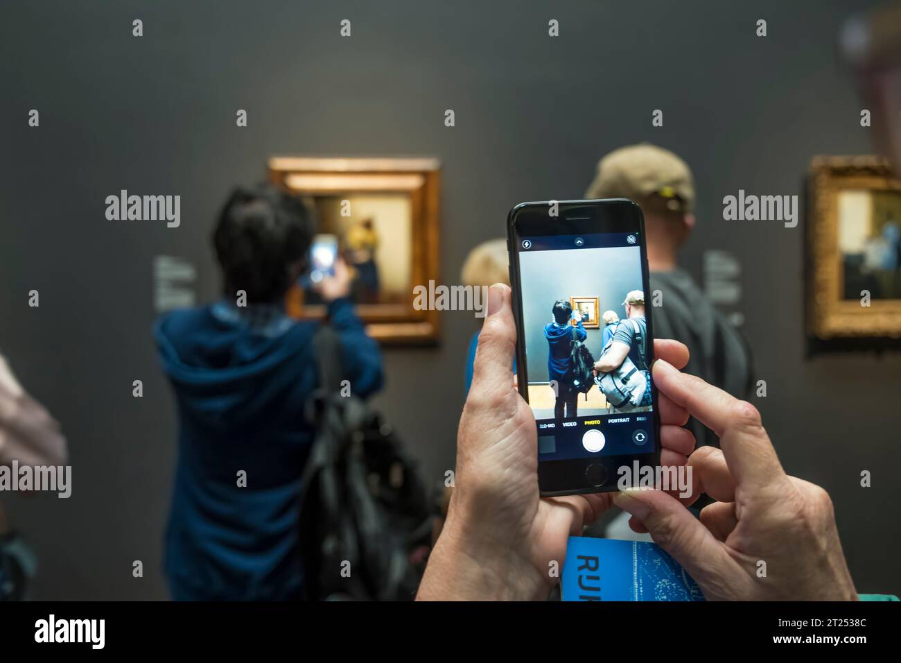 People photographing The Milkmaid by Vermeer from c. 1660 using mobile 'phones in the Rijksmuseum, Amsterdam. Stock Photo