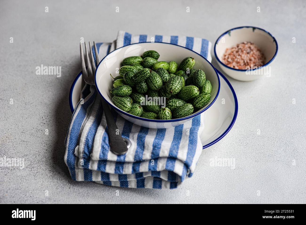 Close-up of a bowl of cucamelons with pink Himalayan salt Stock Photo