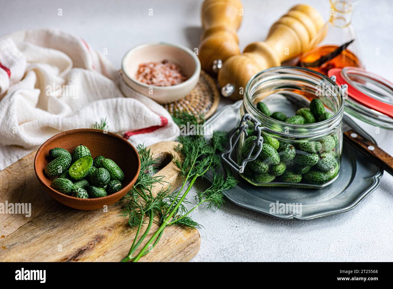 Close-up of fresh cucamelons on a chopping board with herbs and pink Himalayan salt Stock Photo
