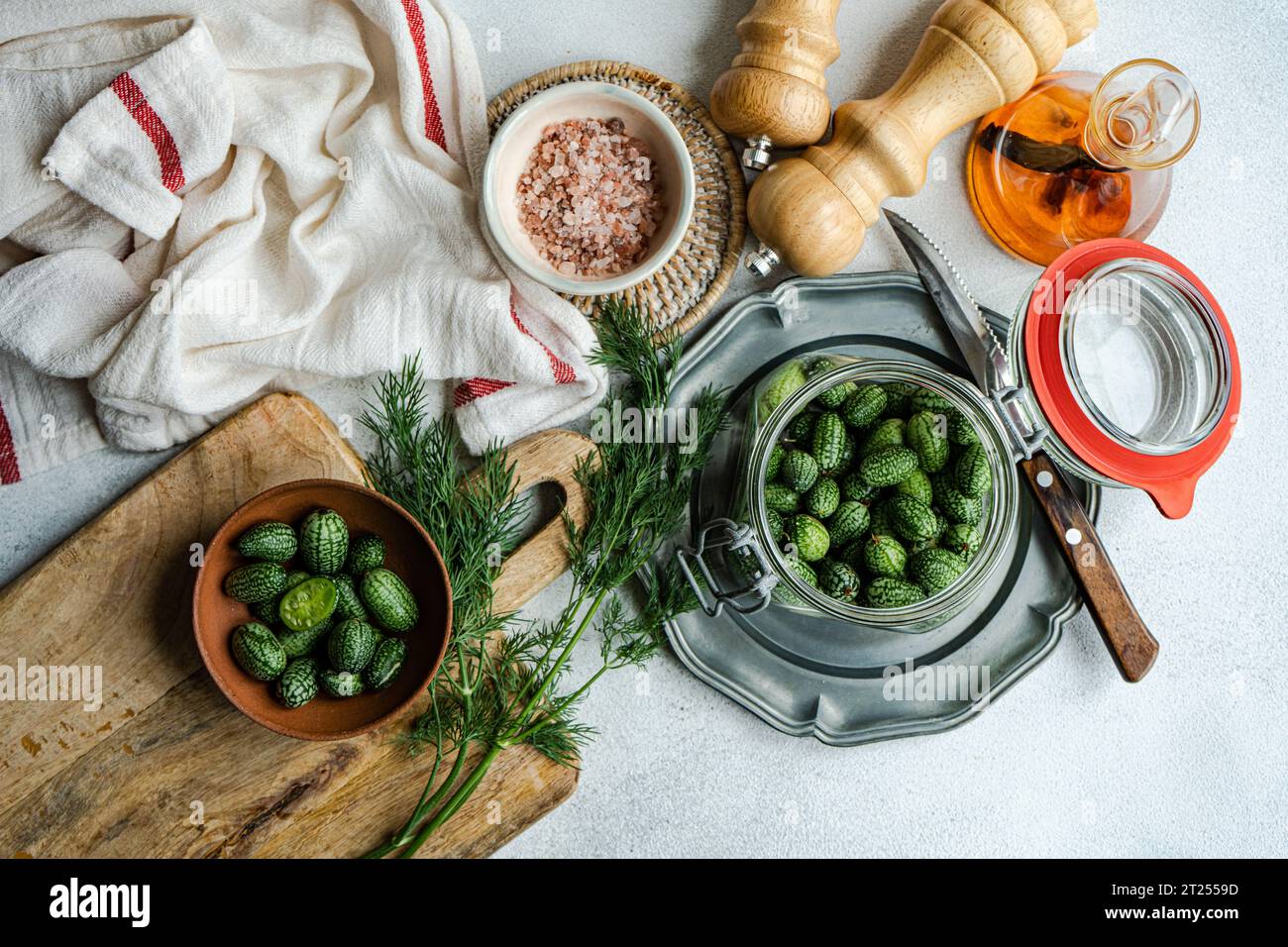 Overhead view of fresh cucamelons on a chopping board with herbs and