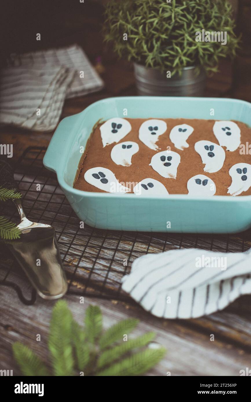 Chocolate brownie Halloween cake with ghost icing decorations on a table Stock Photo Alamy