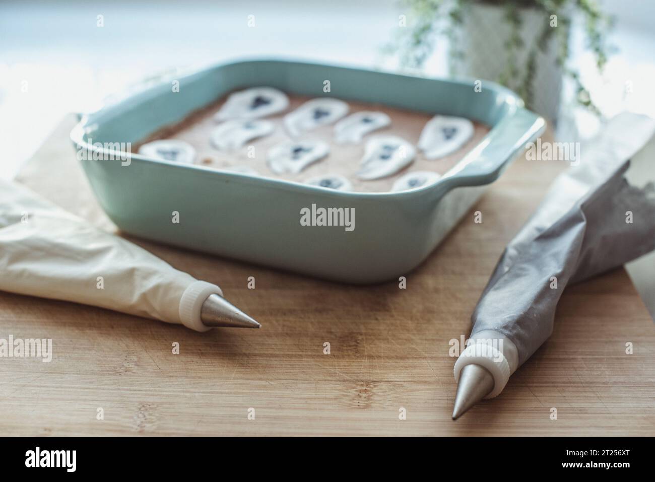 Chocolate brownie Halloween cake with ghost icing decorations on a table with icing bags Stock