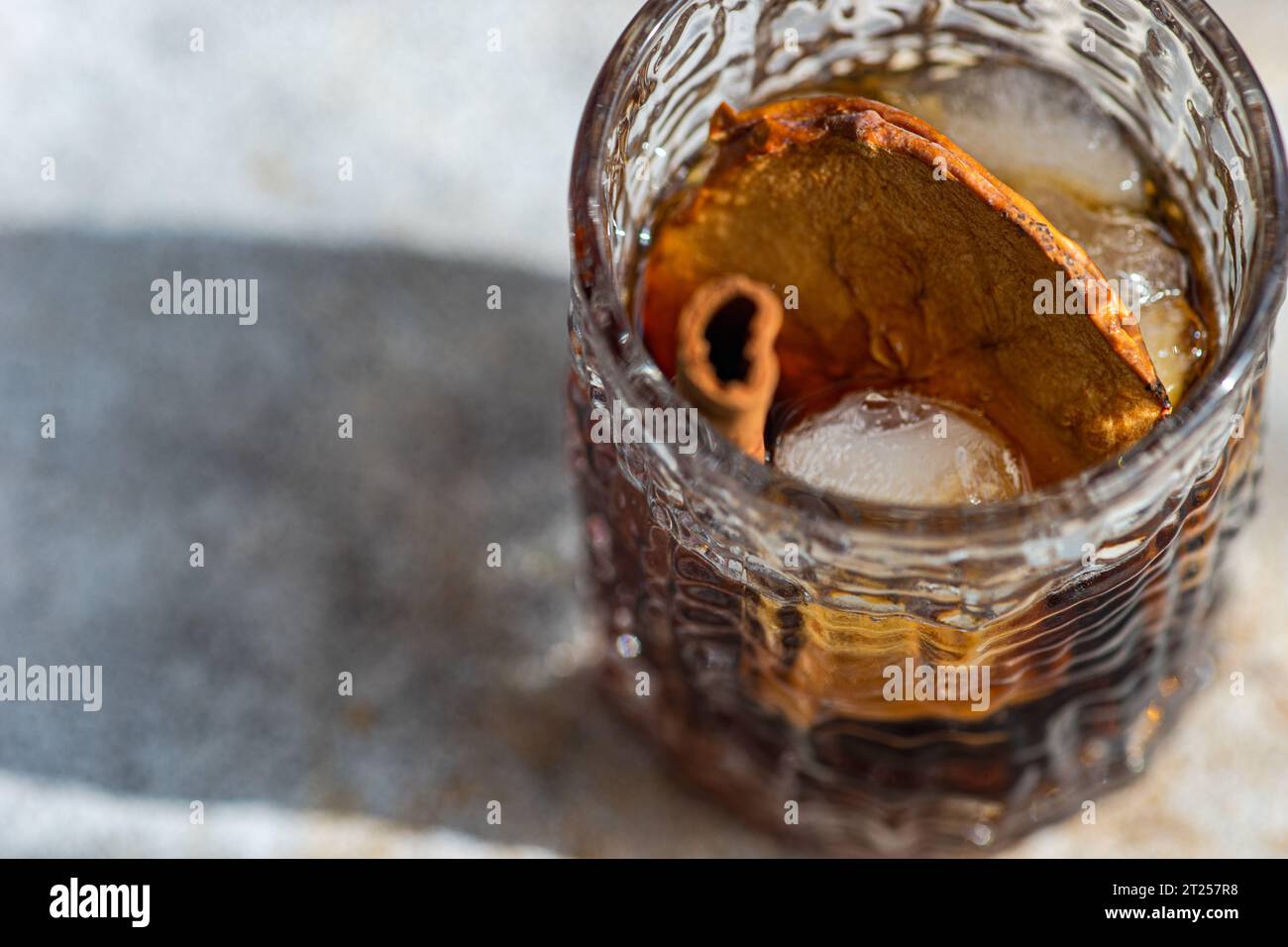 Apple cider cocktail with dried apple slices and a cinnamon stick Stock Photo