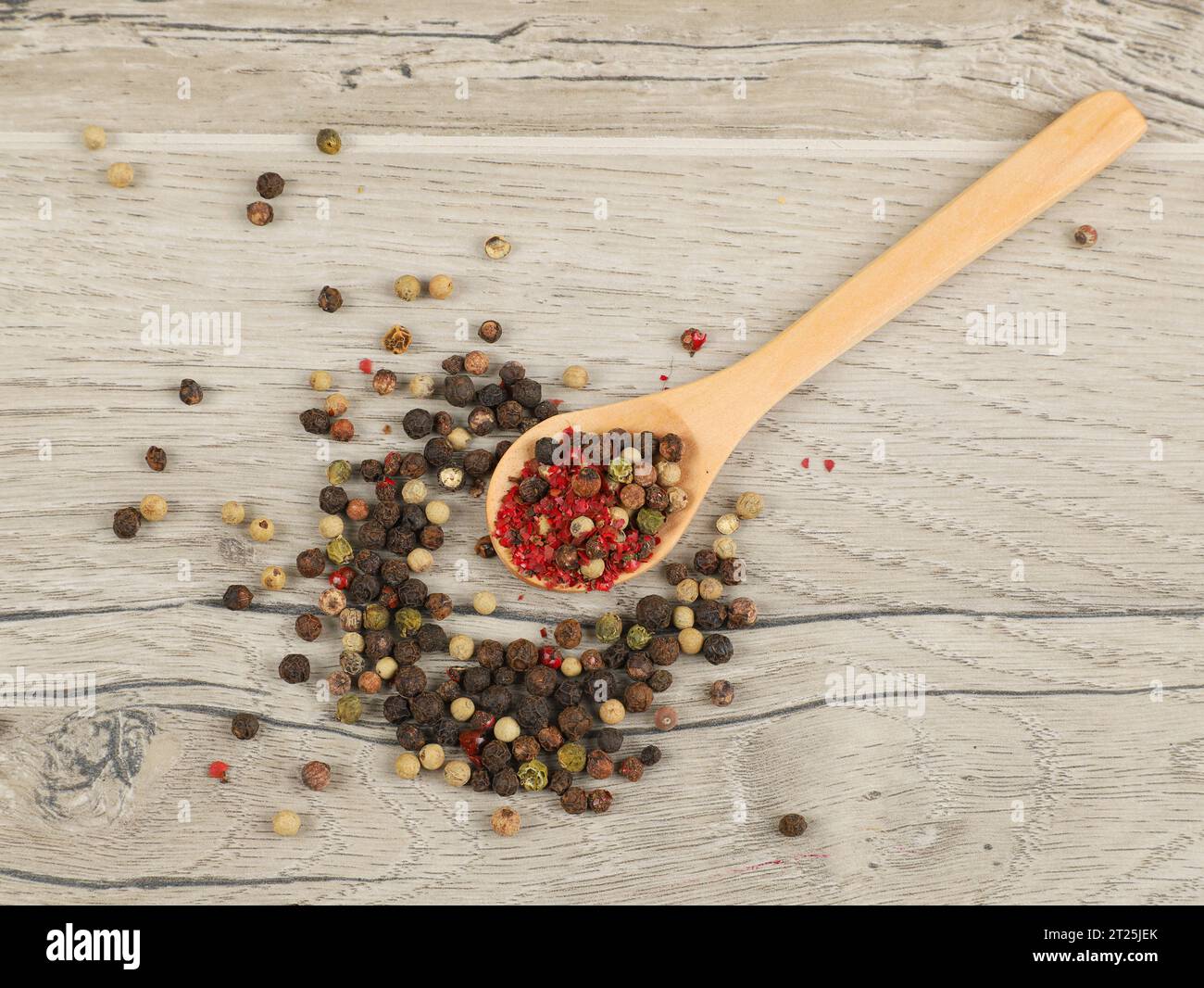 different kinds of dry pepper in spoons on wooden table Stock Photo