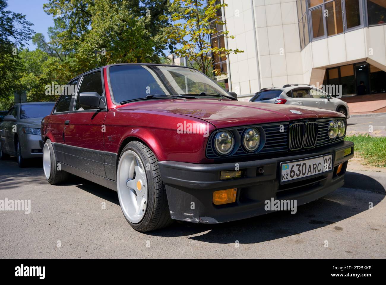 Almaty, Kazakhstan - August 25, 2023: The front of an old BMW 3 Series coupe is burgundy. Street parking Stock Photo