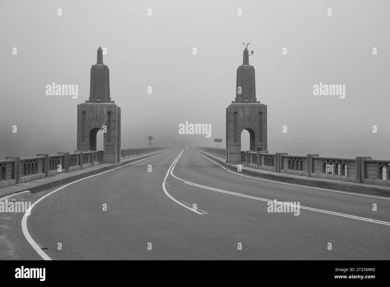 Isaac L. Patterson Bridge on US 101 looking south toward Gold Beach Oregon on a very foggy day - Black and white image. Stock Photo