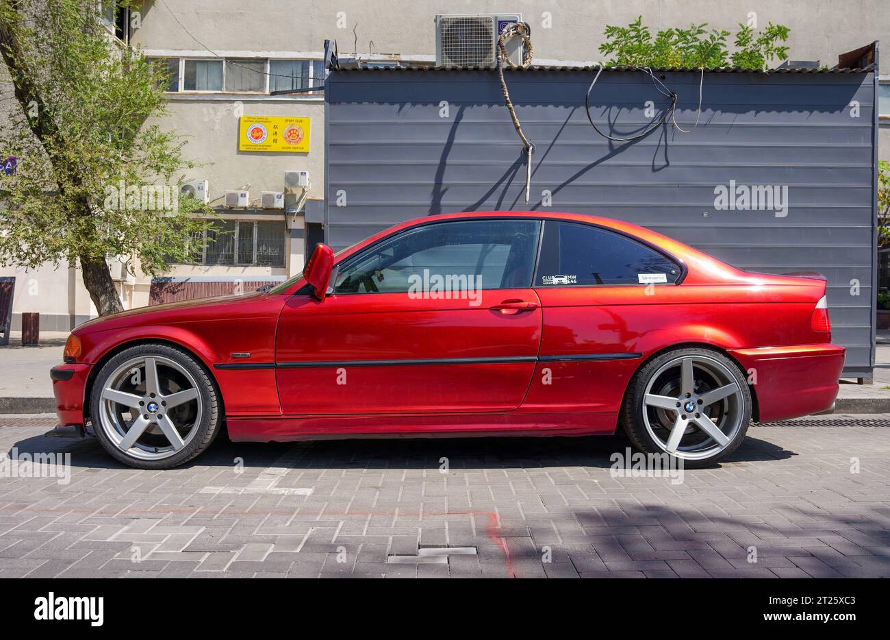 Almaty, Kazakhstan - August 25, 2023: The side of the BMW 3 Series coupe is orange. Street parking Stock Photo