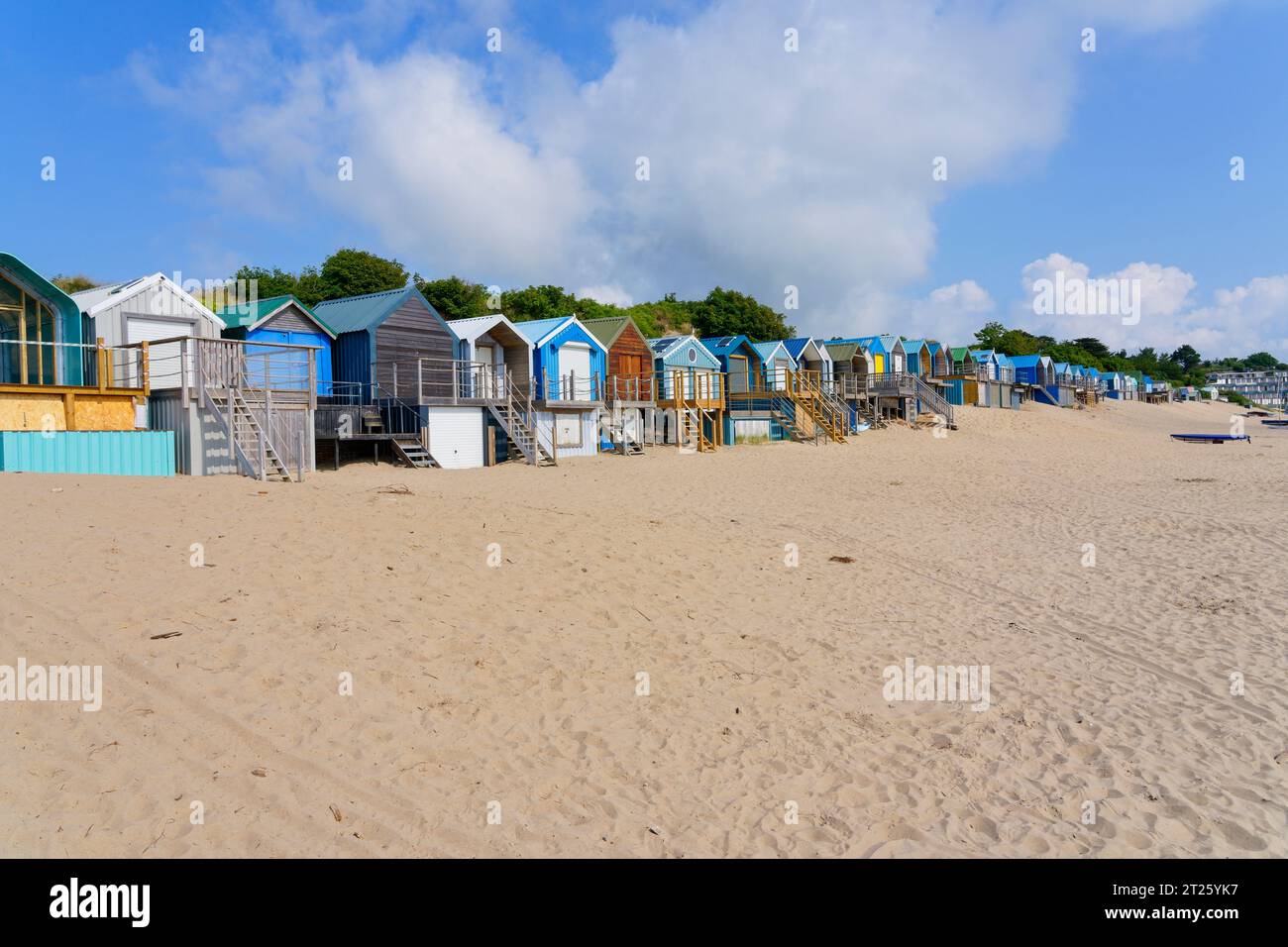 Assorted brightly coloured beach huts down the length of the rear of ...