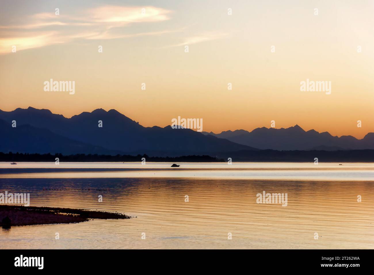impression of lake chiemsee with golden shining light at the evening ...