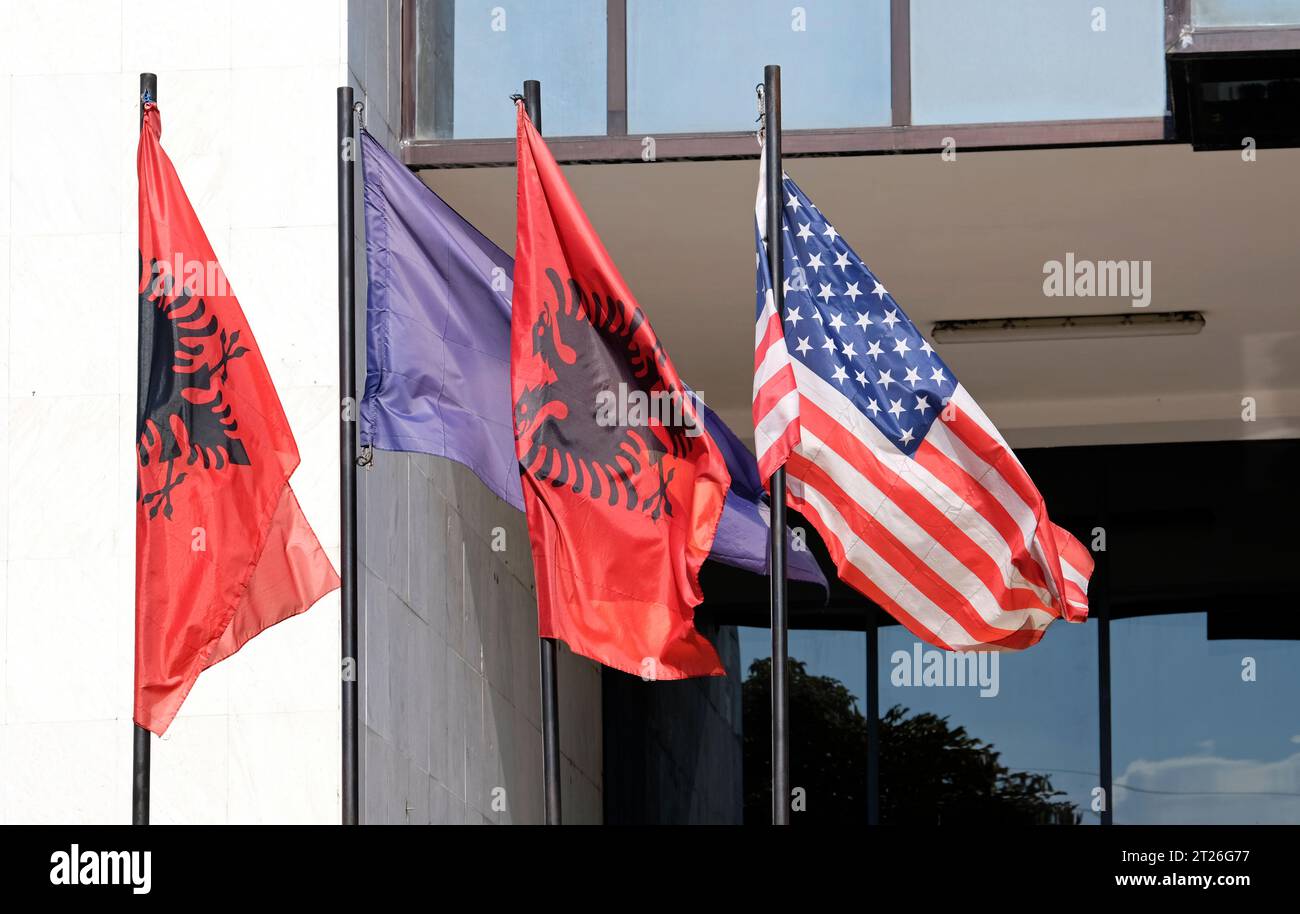 The flags of Kosovo, Albania, and the United States waving in the wind Stock Photo