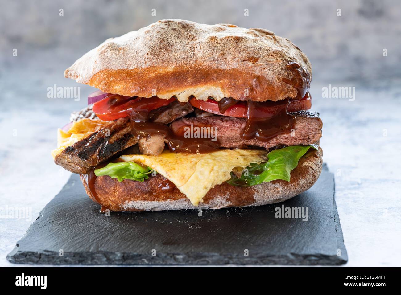 Bread roll with beef rump steak fresh tomato, onion, green lettuce ...