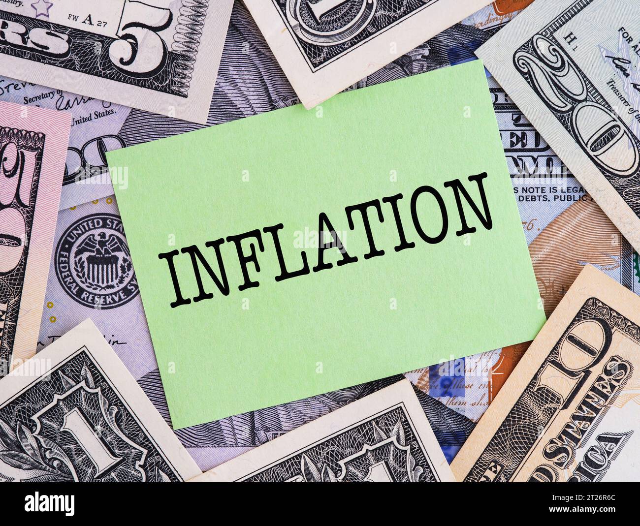 A green paper note with word Inflation on a United States Dollar bills ...